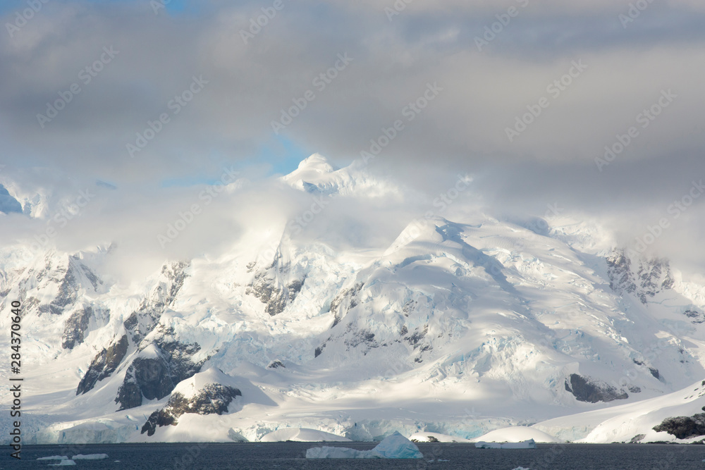 Antarctica. Paradise Harbor. Snowy mountains and clouds.