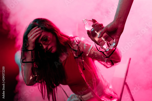Photography sick girl headache taking bottle of water in nightclub
