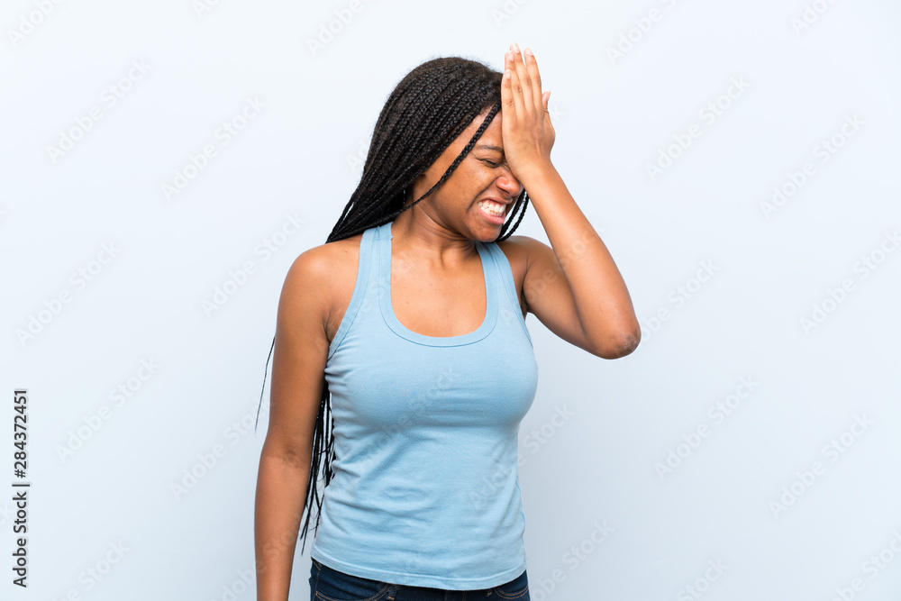 African American teenager girl with long braided hair over isolated blue background having doubts with confuse face expression African American teenager girl with long braided hair over isolated blue background having doubts with confuse face expression