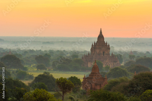 Myanmar. Bagan. Smoke from cooking fires shrouds the temples of Bagan at sunrise.