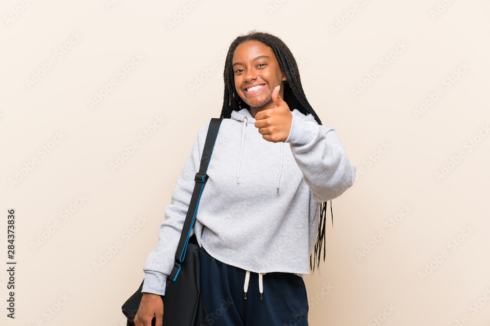 African American sport teenager girl with long braided hair with thumbs up because something good has happened African American sport teenager girl with long braided hair with thumbs up because something good has happened