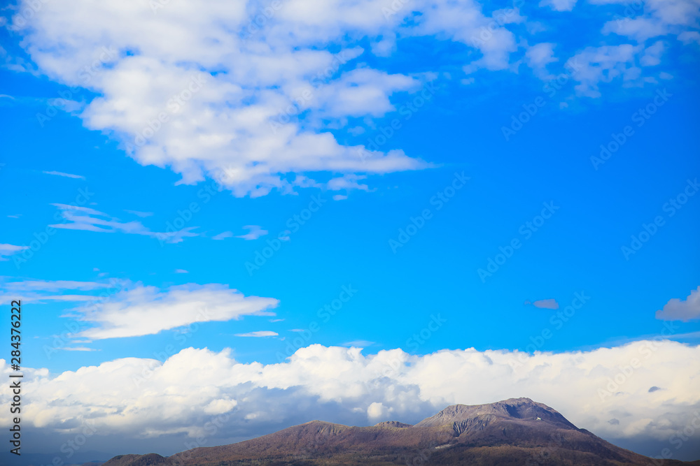 Blue sky with beautiful cloud and the mountain view. Plain landscape background for summer poster. The clouds floating in the sky.nd for summer poster. The clouds floating in the sky.