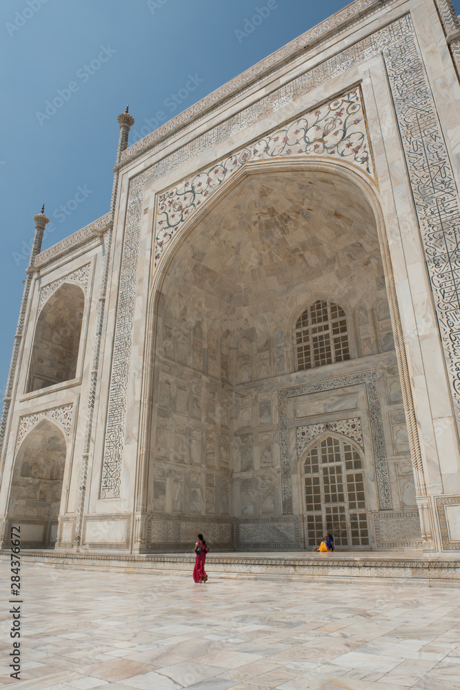 India, Agra, Taj Mahal. Famous landmark memorial to Queen Mumtaz Mahal, circa 1632. UNESCO World Heritage Site. Woman tourist in traditional attire in front of Taj Mahal. For editorial only.