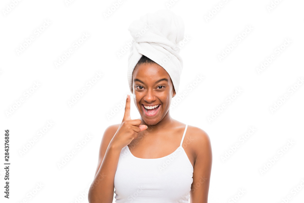 African American teenager girl with moisturizer over isolated white background African American teenager girl with moisturizer over isolated white background