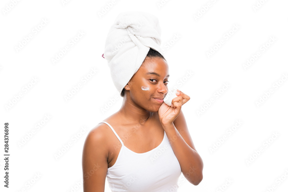 African American teenager girl with moisturizer over isolated white background African American teenager girl with moisturizer over isolated white background
