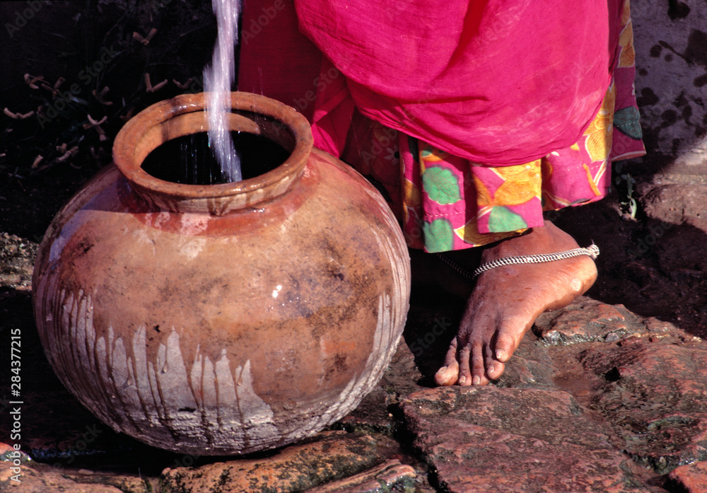 © Ric Ergenbright/Danita Delimont - Asia, India, Rajasthan. A woman in a pretty sari pauses at the well to fill her clay pot in Rajasthan, India. © Ric Ergenbright/Danita Delimont - Asia, India, Rajasthan. A woman in a pretty sari pauses at the well to fill her clay pot in Rajasthan, India.