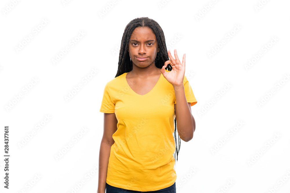 African American teenager girl with long braided hair over isolated white background showing an ok sign with fingers African American teenager girl with long braided hair over isolated white background showing an ok sign with fingers