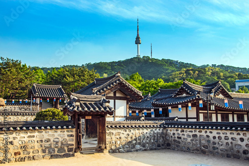 Seoul, South Korea. Traditional Korean village courtyard of Namsangol Hanok with the YTN Seoul Tower (Namsan Tower or Seoul Tower) in the background. photo