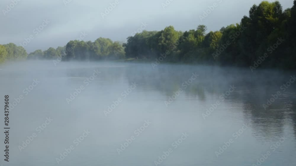 Foggy river surface and green trees countryside landscape. Real time full hd video footage. Foggy river surface and green trees countryside landscape. Real time full hd video footage.