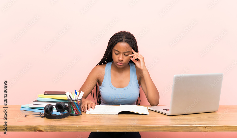 African American teenager student girl with long braided hair in her workplace African American teenager student girl with long braided hair in her workplace