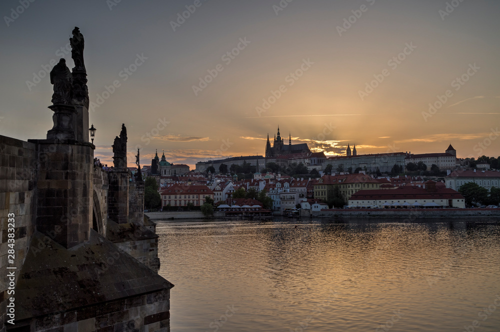 View of the Charles Bridge (Karluv most) over Vltava River, Mala Strana district and Prague (Hradcany) Castle in Prague, Czech Republic, at sunset. Copy space.