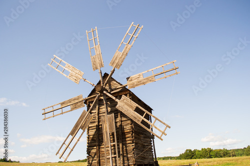 Old wooden windmill against a blue sky