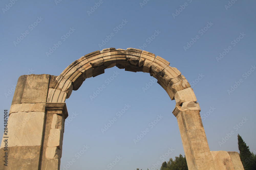 Doorway arch along the Marble Road in the ancient city ruins of Ephesus, Turkey near Selcuk with blue sky copy space.