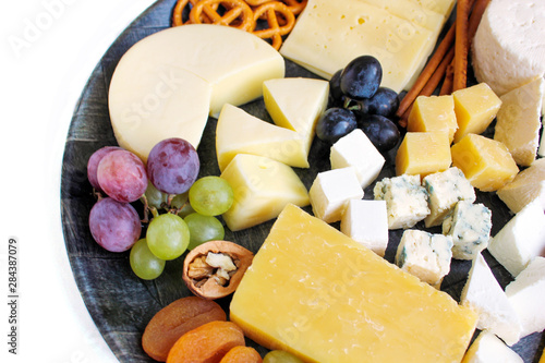 Rustic cheese platter with different cheese and grapes