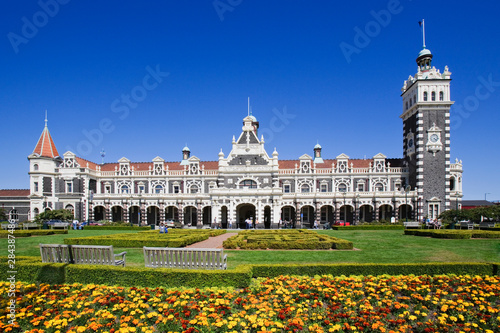 New Zealand, South Island, Dunedin. Outside view of ornate Railway Station and gardens. 