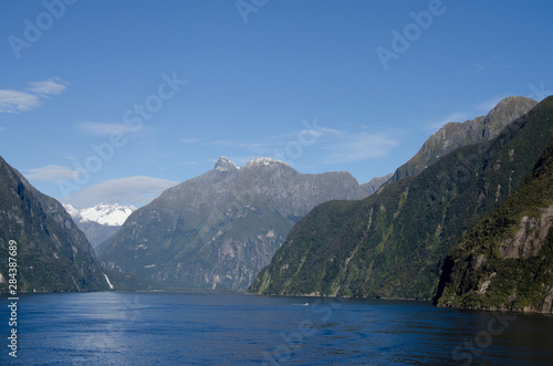 New Zealand, South Island, Fiordland National Park, Milford Sound aka Piopiotahi. Scenic fjord with snow-capped mountains and waterfall.