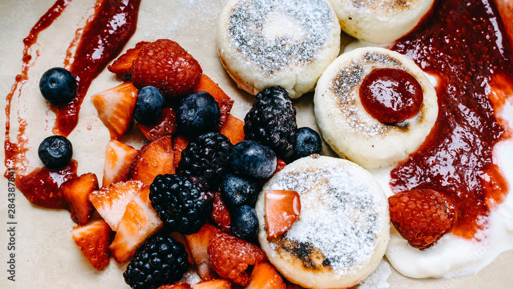 Homemade pancakes serving with fresh raspberry, blueberry, strawberry, with sauce and pondered sugar, selective focus, banner Homemade pancakes serving with fresh raspberry, blueberry, strawberry, with sauce and pondered sugar, selective focus, banner