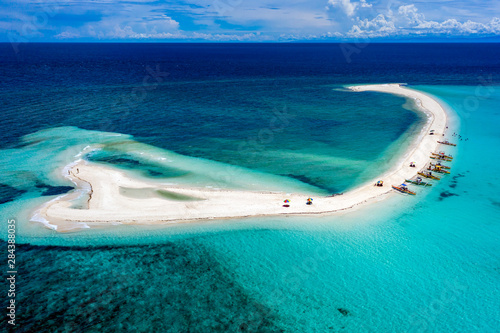 Aerial drone view of a spectacular sandbar surrounded by coral reef located off a tropical island (White Island, Camiguin, Philippines)