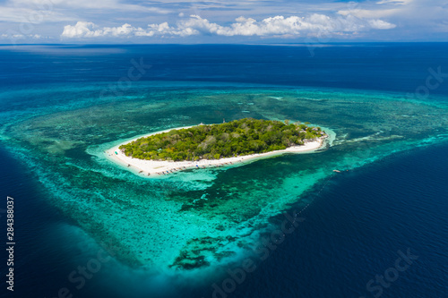 Aerial drone view of a beautiful tropical island surrounded by coral reef (Mantigue Island, Camiguin, Philippines) © whitcomberd