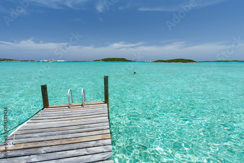 Dock in the foreground  clear water and blue sky in the background  taken on Staniel Cay  Exuma  Bahamas