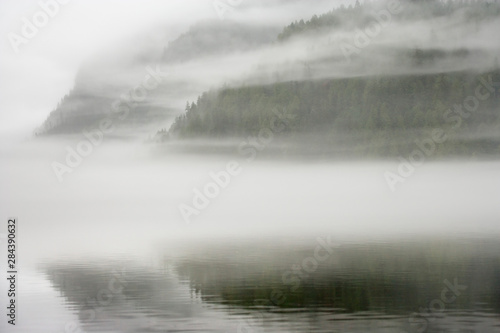 Canada, British Columbia, Calvert Island. Mist and fog shroud water and fores...