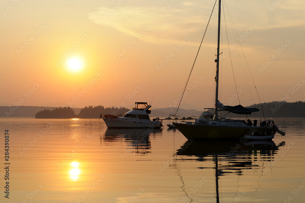 Canada, British Columbia, Gulf Islands, Wallace Island. Boats at anchor in front of setting sun