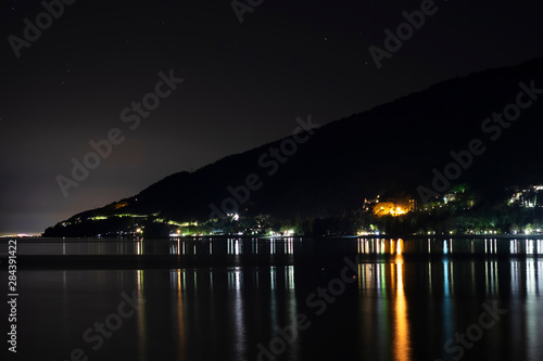 Night city in the reflection of the water of the sea. Night beach of pebbles Abkhazia Gagra. Black night, highlands, tourism, travel, night city.