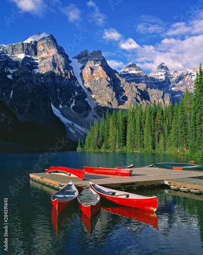 Canada, Alberta, Moraine Lake. Red canoes await canoers at Moraine Lake in the Valley of the Ten Peaks, in Alberta's Banff NP, a World Heritage Site.