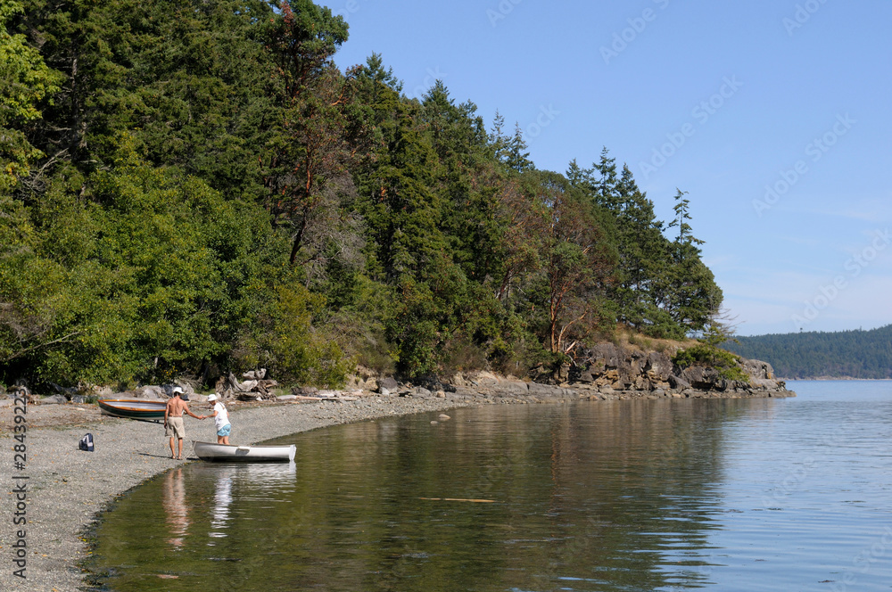 Canada, British Columbia, Gulf Islands, Portland Island. People getting out of a dinghy at the beach in Princess Bay