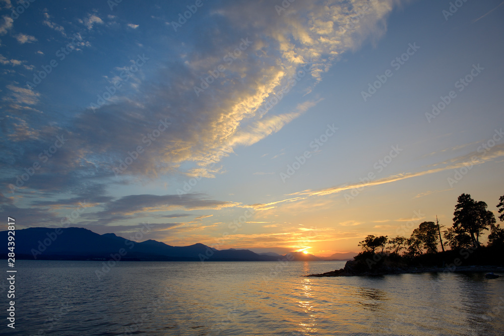 Canada, British Columbia, Gulf Islands, Tent Island. Sunset over Vancouver Island with clouds