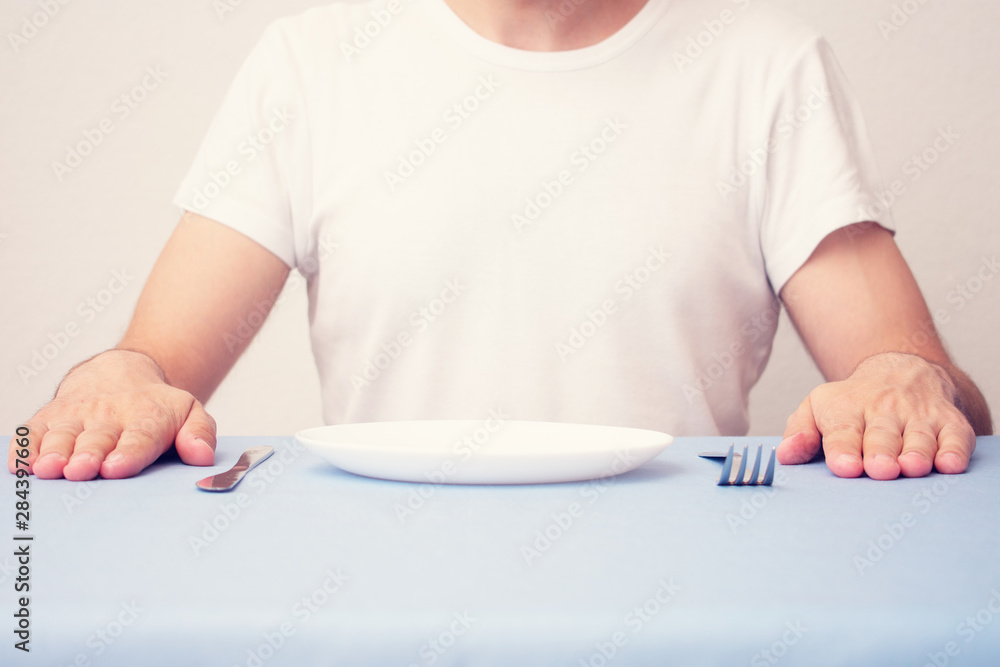 A man sitting at the dinner table, a man waiting for his dinner, front view, men's hands, closeup, cropped image A man sitting at the dinner table, a man waiting for his dinner, front view, men's hands, closeup, cropped image