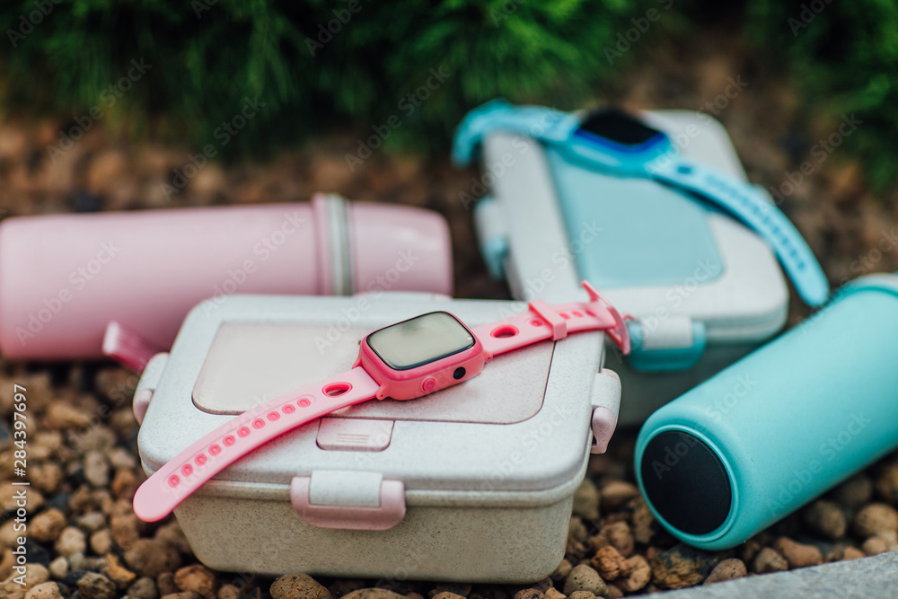 Close up photo. Focus at smart watches for children with lunch boxes. Food concept.