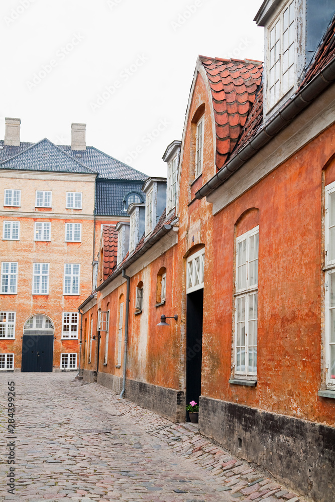 Copenhagen, Denmark - An image of an old world, cobblestone street and surrounding buildings.