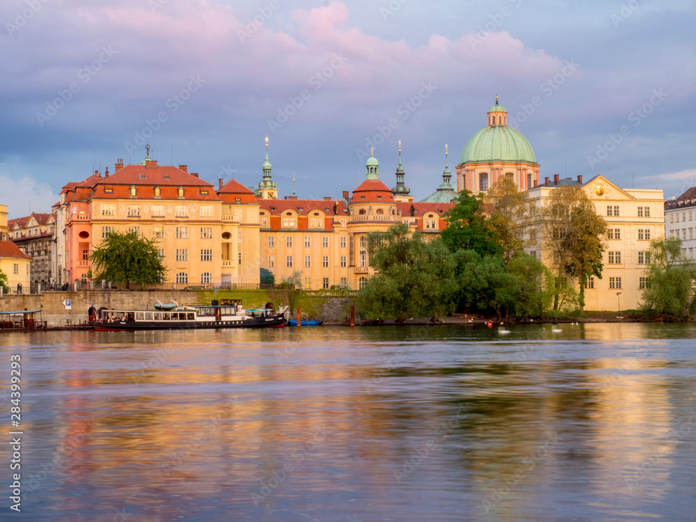 Czech Republic, Prague. Dusk on the Vltava river with the buildings of Lesser Town and the dome of St. Nicholas Cathedral.