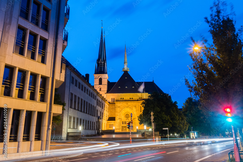 Night view of street in Luxembourg with Notre-Dame Cathedral in background.