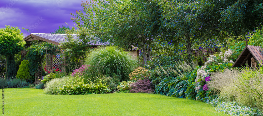 Naklejka premium Zielony trawnik w pięknym ogrodzie