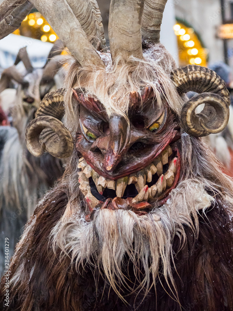 Obraz premium Krampuslauf or Perchtenlauf during advent in Munich, an old tradition taking place during Christmas in the Bavarian Alps, Austria and South Tyrol, Germany.