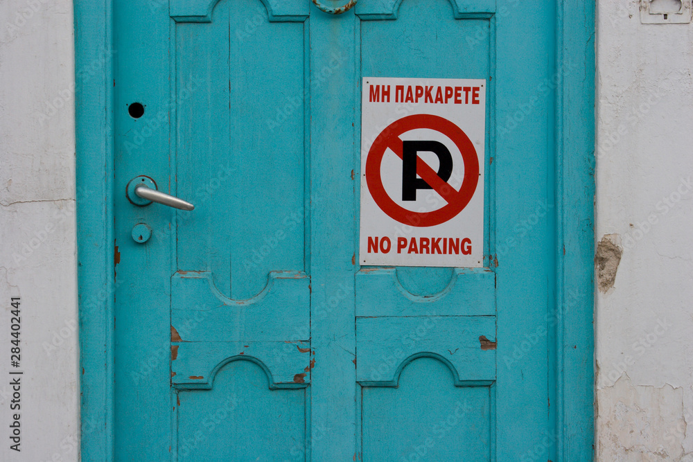 Greece, Mykonos, Hora. Door with No Parking sign in English and Greek. Greece, Mykonos, Hora. Door with No Parking sign in English and Greek.