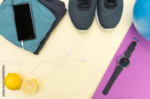 Flat lay with sportswear, fitness equipment and gadgets, smartphone and smartwatch. Fitness technology