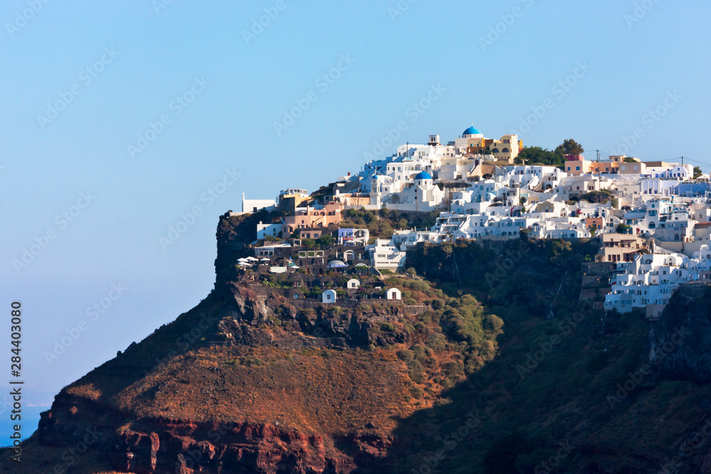 Houses perched on the cliff on the coast of Aegean Sea, Santorini Island, Greece