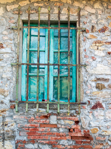 Italy, Tuscany. Turquoise window on brick building.