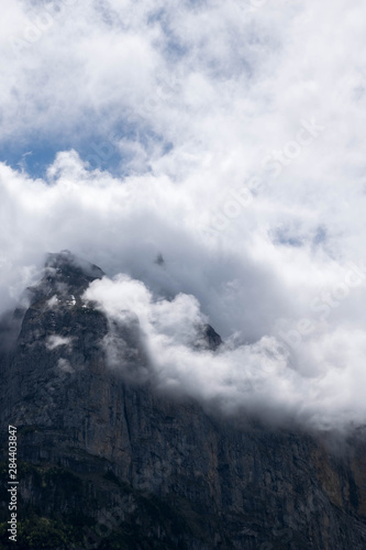 Alpine peak with beautiful white clouds on top