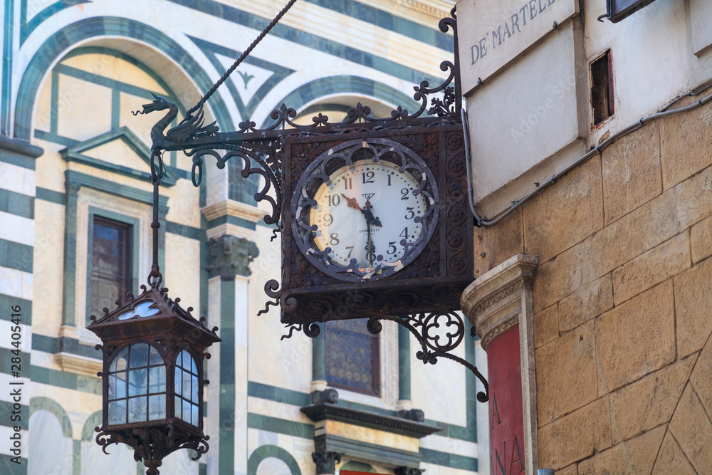 Italy, Florence. Wrought-iron clock and hanging lantern.