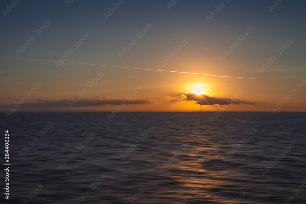 Sunset on the sea with italian coastline background