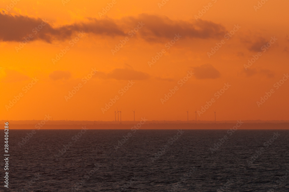 Wind turbines on italian coast at sunset
