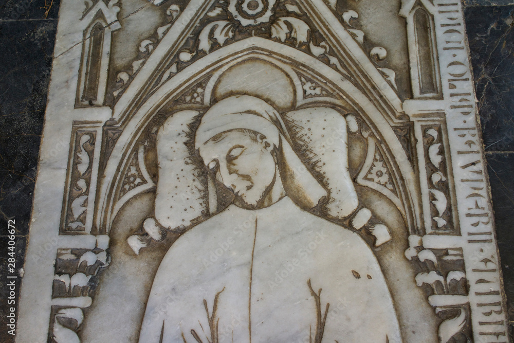 Italy, Tuscany, Pisa, Piazza dei Miracoli. Marble sepulcher cover inside the Battistero. Elegant tunic and slippers.