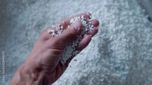 Plastic granules are poured from the hand. Plastic granules, dye, polymer granules are used for the production of plastic products