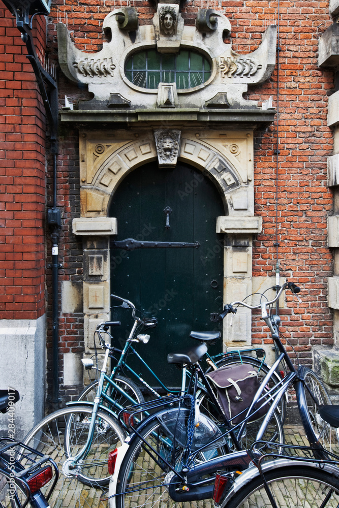 Netherlands, Amsterdam. Bicycles parked in front of building door. 