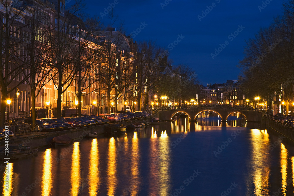 Netherlands, Amsterdam. Bridge and lights reflect on Keizergracht Canal at night. 