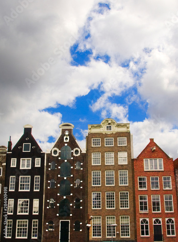 View of the unique architecture and gabled homes along a colorful canal with fluffy clouds